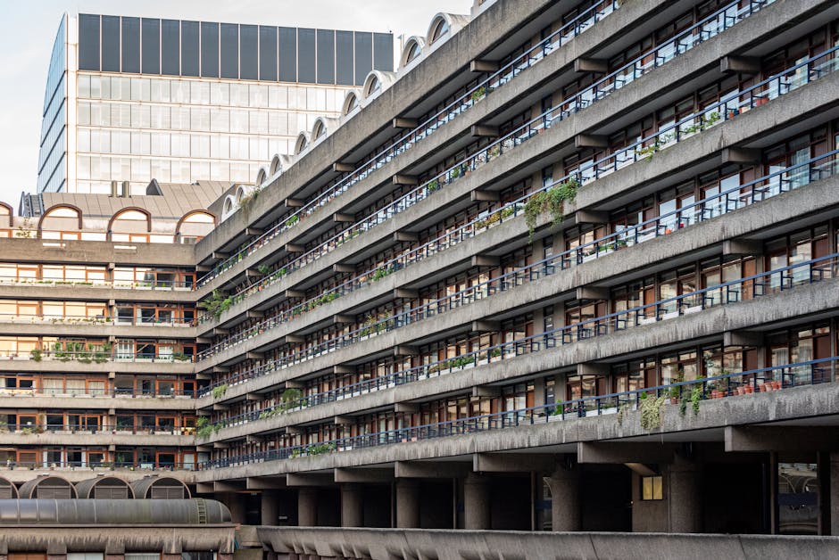 A multi-story residential building with several rows of balconies featuring dark metal railings, each adorned with various potted plants and hanging greenery, creating a lush appearance along the faca